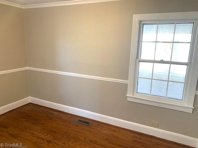 unfurnished room with dark hardwood / wood-style floors and ornamental molding