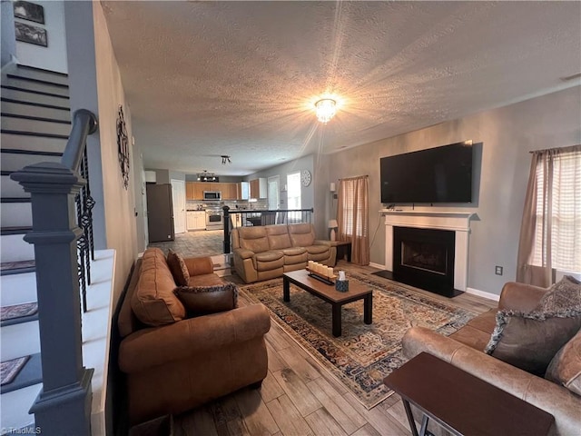 5227 Eagle Creek Dr, Charlotte, NC 28269 - living area with a textured ceiling, wood finished floors, stairway, a fireplace with flush hearth, and baseboards