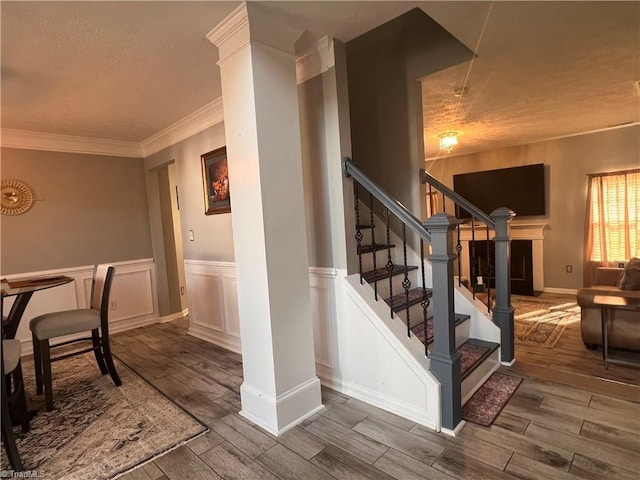 5227 Eagle Creek Dr, Charlotte, NC 28269 - stairway featuring wood finished floors, a wainscoted wall, ornamental molding, and a textured ceiling