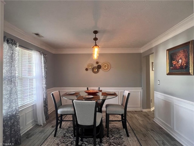 5227 Eagle Creek Dr, Charlotte, NC 28269 - dining space with healthy amount of natural light, wood finished floors, crown molding, a decorative wall, and a wainscoted wall