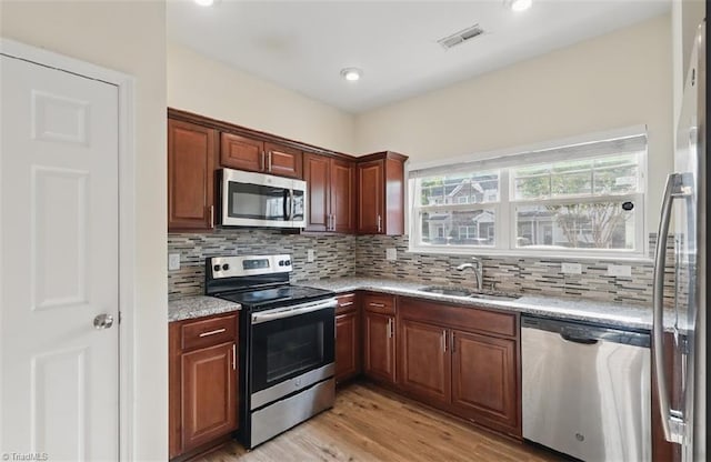 5227 Eagle Creek Dr, Charlotte, NC 28269 - kitchen featuring stainless steel appliances, a sink, backsplash, light wood-type flooring, and recessed lighting