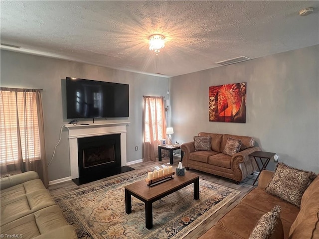 5227 Eagle Creek Dr, Charlotte, NC 28269 - living room with a textured ceiling, plenty of natural light, a fireplace with raised hearth, and wood finished floors