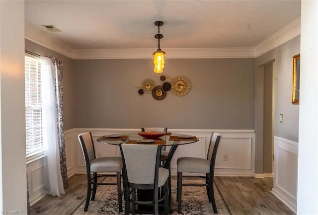 5227 Eagle Creek Dr, Charlotte, NC 28269 - dining room with wood finished floors, crown molding, a decorative wall, and wainscoting