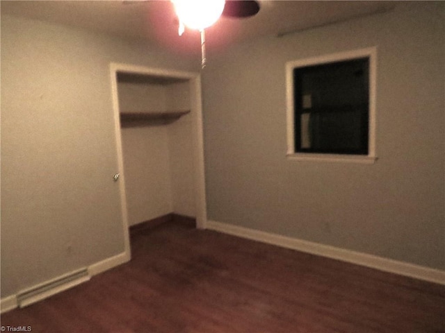 unfurnished bedroom with dark wood-type flooring and a closet