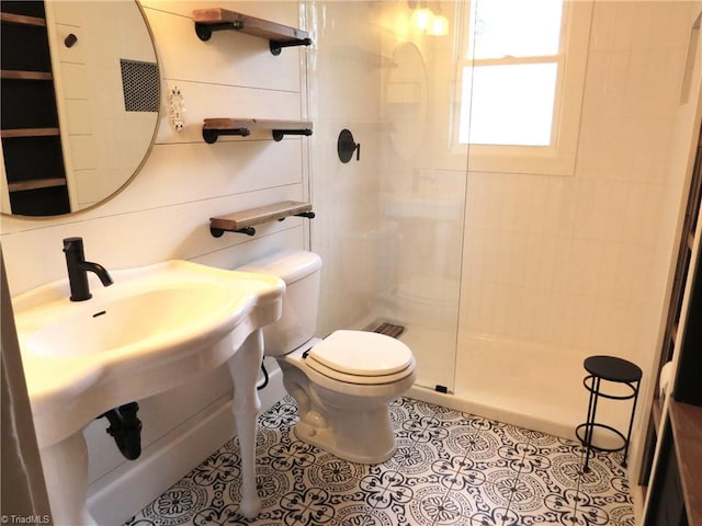 bathroom featuring tile patterned floors, toilet, and an enclosed shower