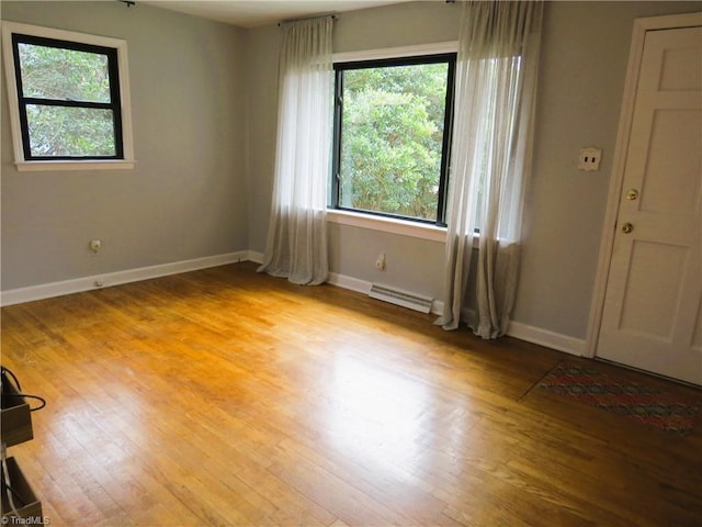 unfurnished room with light hardwood / wood-style flooring and a baseboard heating unit