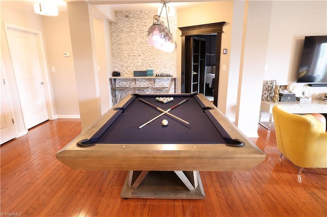 playroom featuring hardwood / wood-style floors, a stone fireplace, and pool table