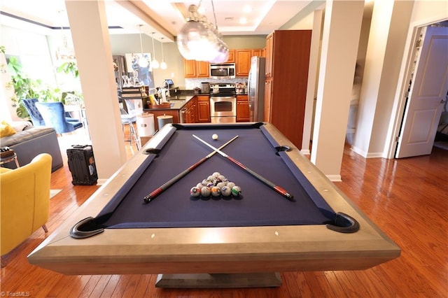 game room with a raised ceiling, sink, light wood-type flooring, and pool table