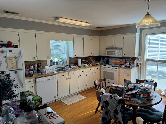 kitchen with pendant lighting, white appliances, white cabinetry, and plenty of natural light