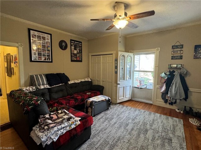 living room with hardwood / wood-style floors, a textured ceiling, ceiling fan, and ornamental molding