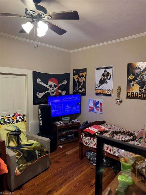 rec room with ceiling fan, wood-type flooring, and ornamental molding