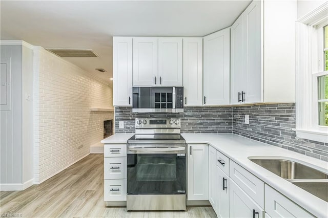 kitchen featuring stainless steel appliances, decorative backsplash, and light countertops