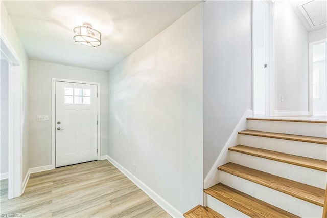 entrance foyer featuring light wood-type flooring, baseboards, and stairway