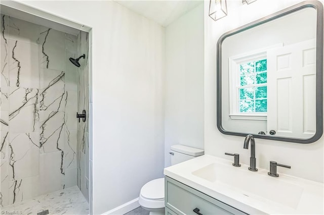 full bathroom featuring toilet, a marble finish shower, vanity, and baseboards