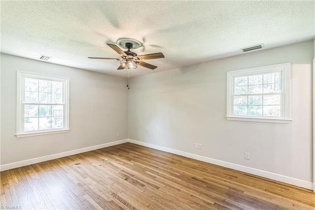 unfurnished room with ceiling fan, wood-type flooring, baseboards, and a textured ceiling