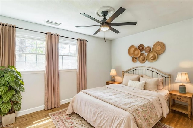 bedroom featuring wood finished floors, baseboards, and ceiling fan