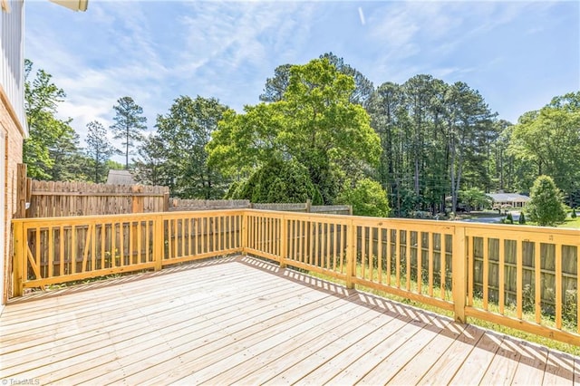 wooden terrace with a fenced backyard