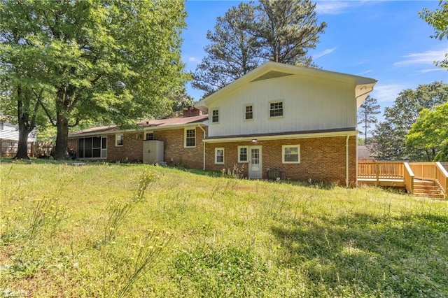 back of property with a wooden deck, brick siding, and central AC