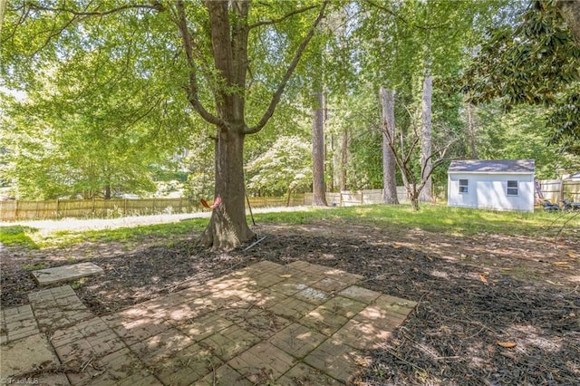 view of yard featuring a patio area, fence, and an outdoor structure