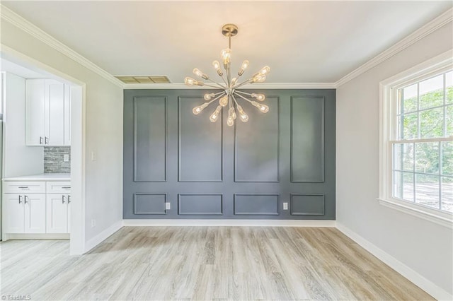 unfurnished dining area with a chandelier, light wood-style floors, healthy amount of natural light, baseboards, and ornamental molding