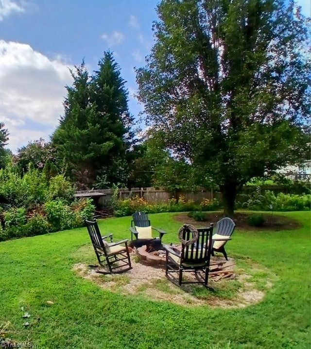 view of community with a fire pit and a lawn