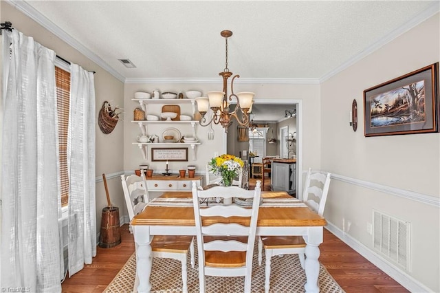 dining room featuring hardwood / wood-style flooring, ornamental molding, and a chandelier