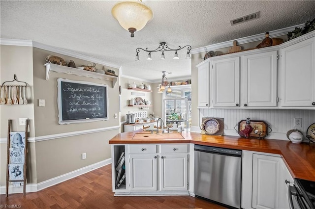 kitchen featuring sink, white cabinetry, wood counters, decorative light fixtures, and stainless steel dishwasher