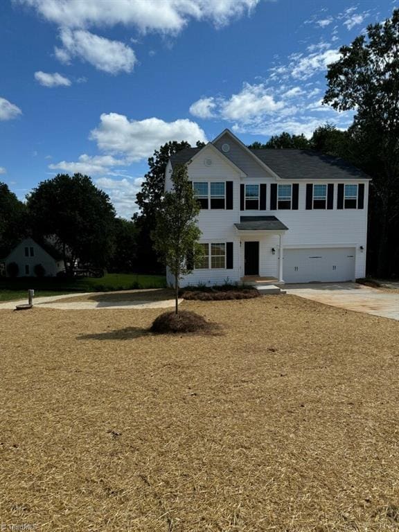 view of front of house with a garage and a front lawn