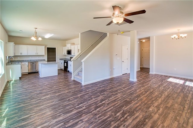 unfurnished living room featuring ceiling fan with notable chandelier, sink, and dark wood-type flooring