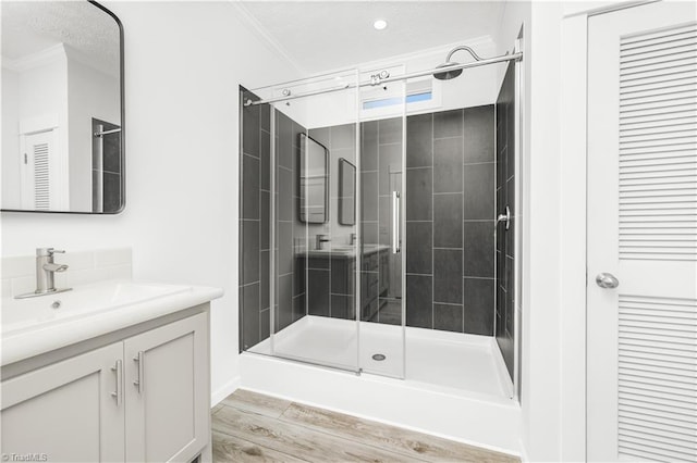 bathroom with walk in shower, ornamental molding, and vanity