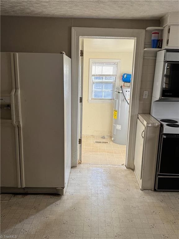 kitchen featuring range with electric cooktop, water heater, white refrigerator with ice dispenser, a textured ceiling, and white cabinets