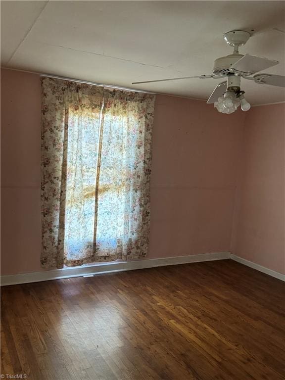 spare room with dark hardwood / wood-style flooring and ceiling fan