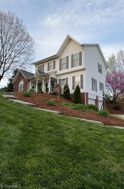 traditional home with brick siding and a front yard