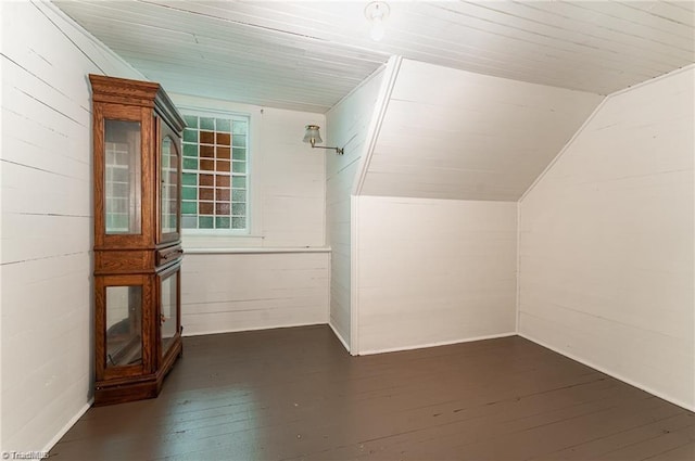 additional living space with vaulted ceiling and dark hardwood / wood-style flooring