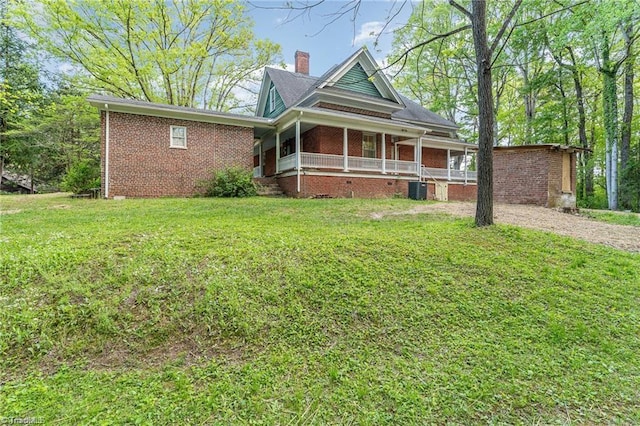 view of front of house featuring central AC unit, a front yard, and covered porch