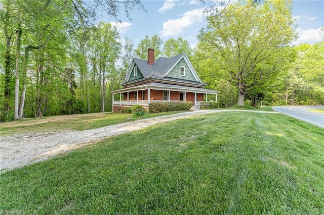 farmhouse-style home with covered porch and a front yard