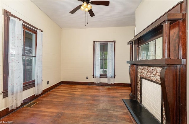 unfurnished living room with ceiling fan and dark wood-type flooring