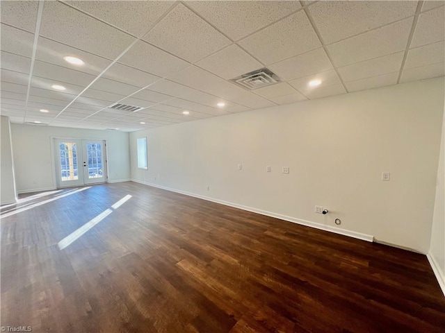 spare room with a paneled ceiling, dark hardwood / wood-style flooring, and french doors