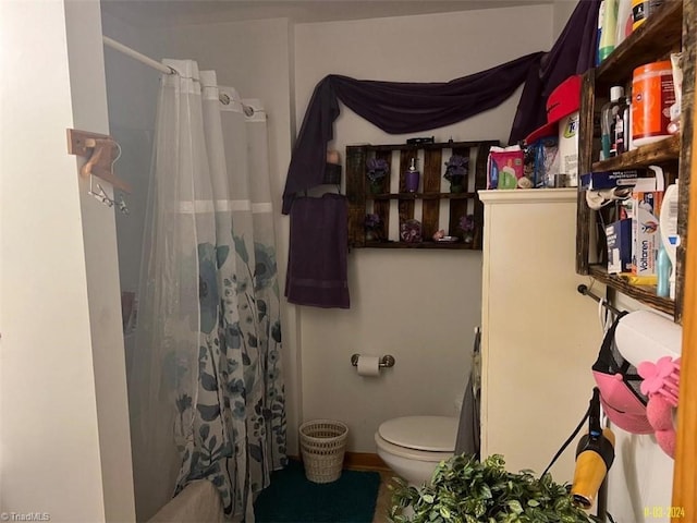 bathroom featuring a shower with curtain and toilet