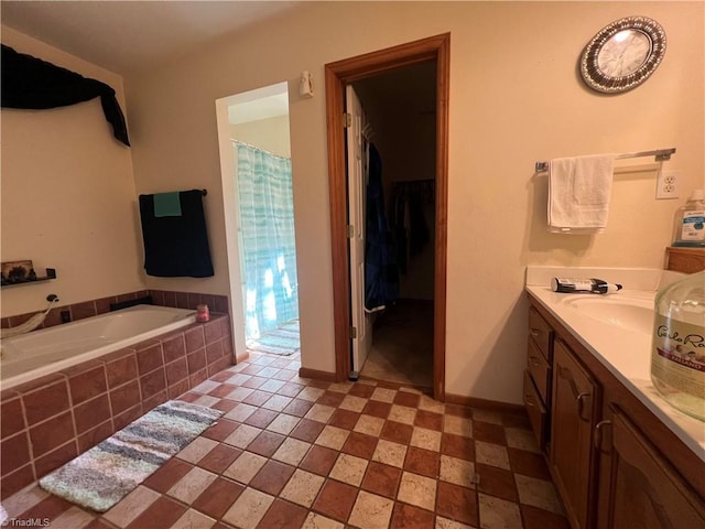 bathroom with vanity and a relaxing tiled tub