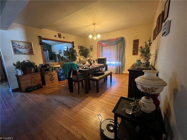 dining space with light wood-type flooring and an inviting chandelier