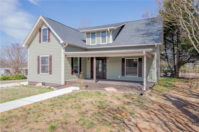 view of front of house with a porch, a shingled roof, and a front lawn