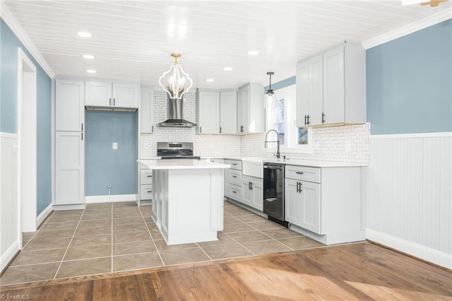 kitchen with a wainscoted wall, light countertops, electric stove, dishwasher, and wall chimney exhaust hood