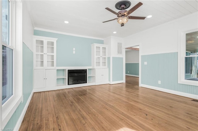 unfurnished living room featuring ornamental molding, a fireplace, and wood finished floors