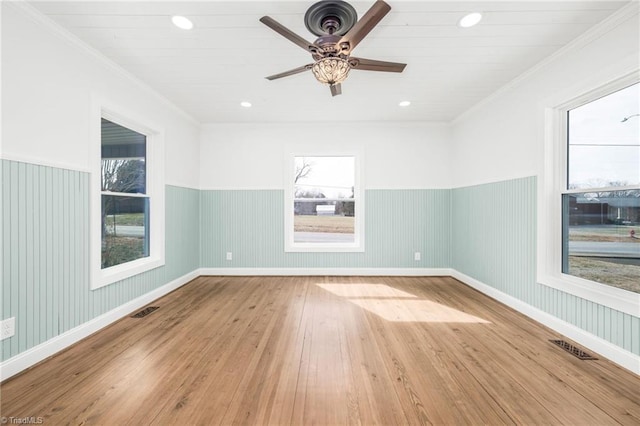 unfurnished room with a wainscoted wall, crown molding, recessed lighting, visible vents, and hardwood / wood-style floors