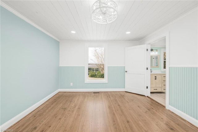 unfurnished bedroom with wood ceiling, wood-type flooring, ornamental molding, and wainscoting