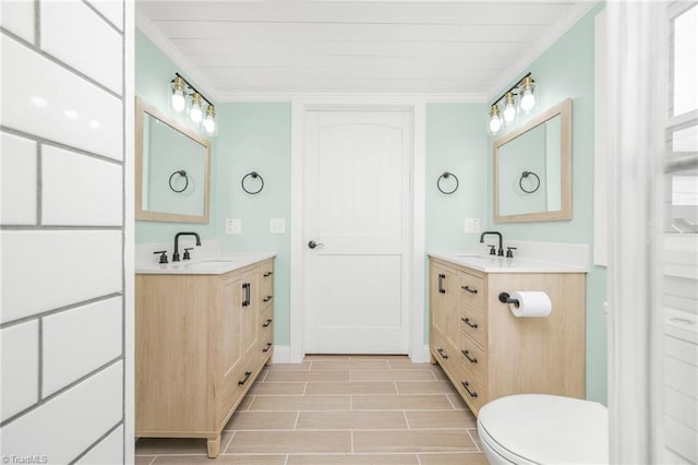 full bath featuring crown molding, two vanities, and a sink