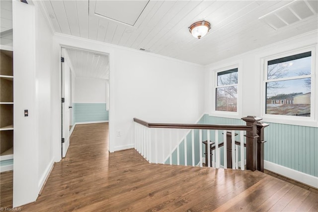 hall featuring visible vents, wooden ceiling, wood finished floors, and an upstairs landing