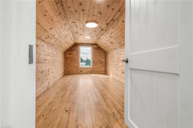 bonus room featuring lofted ceiling, wood ceiling, wooden walls, and hardwood / wood-style flooring