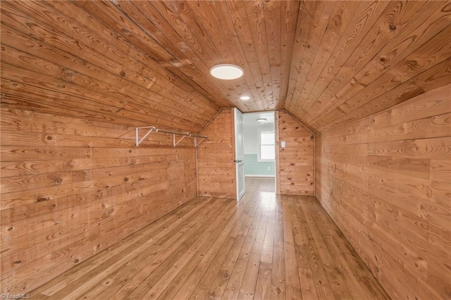 additional living space with vaulted ceiling, wood walls, wood-type flooring, and wood ceiling